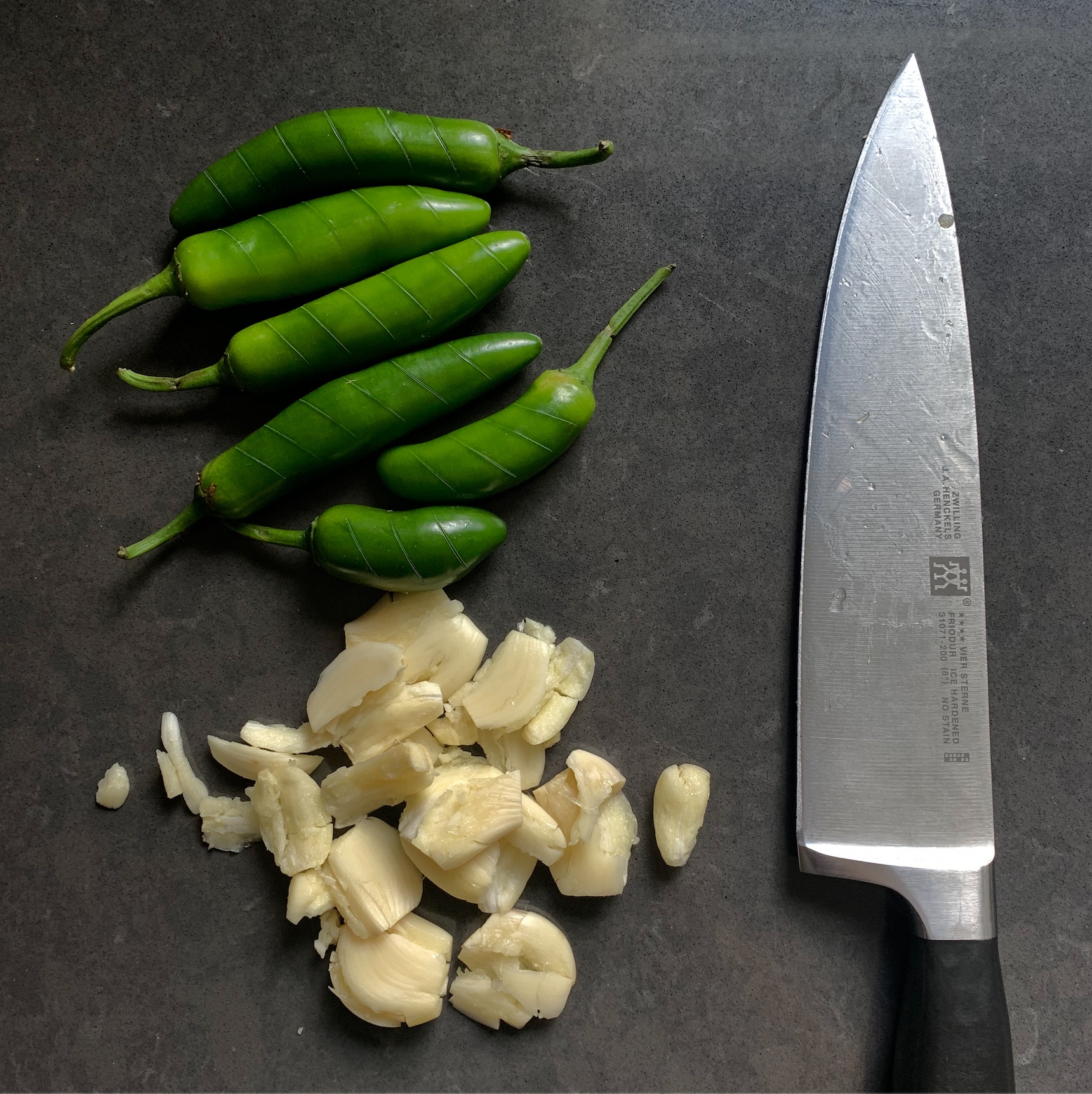 scored peppers and crushed garlic