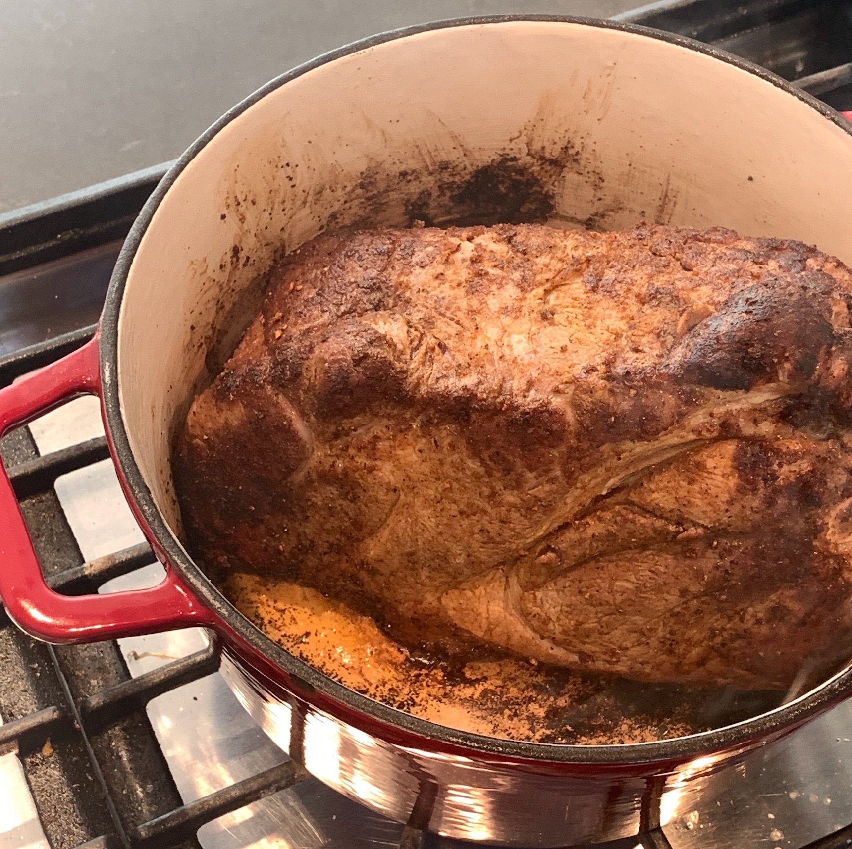 Pork shoulder being seared in a dutch oven