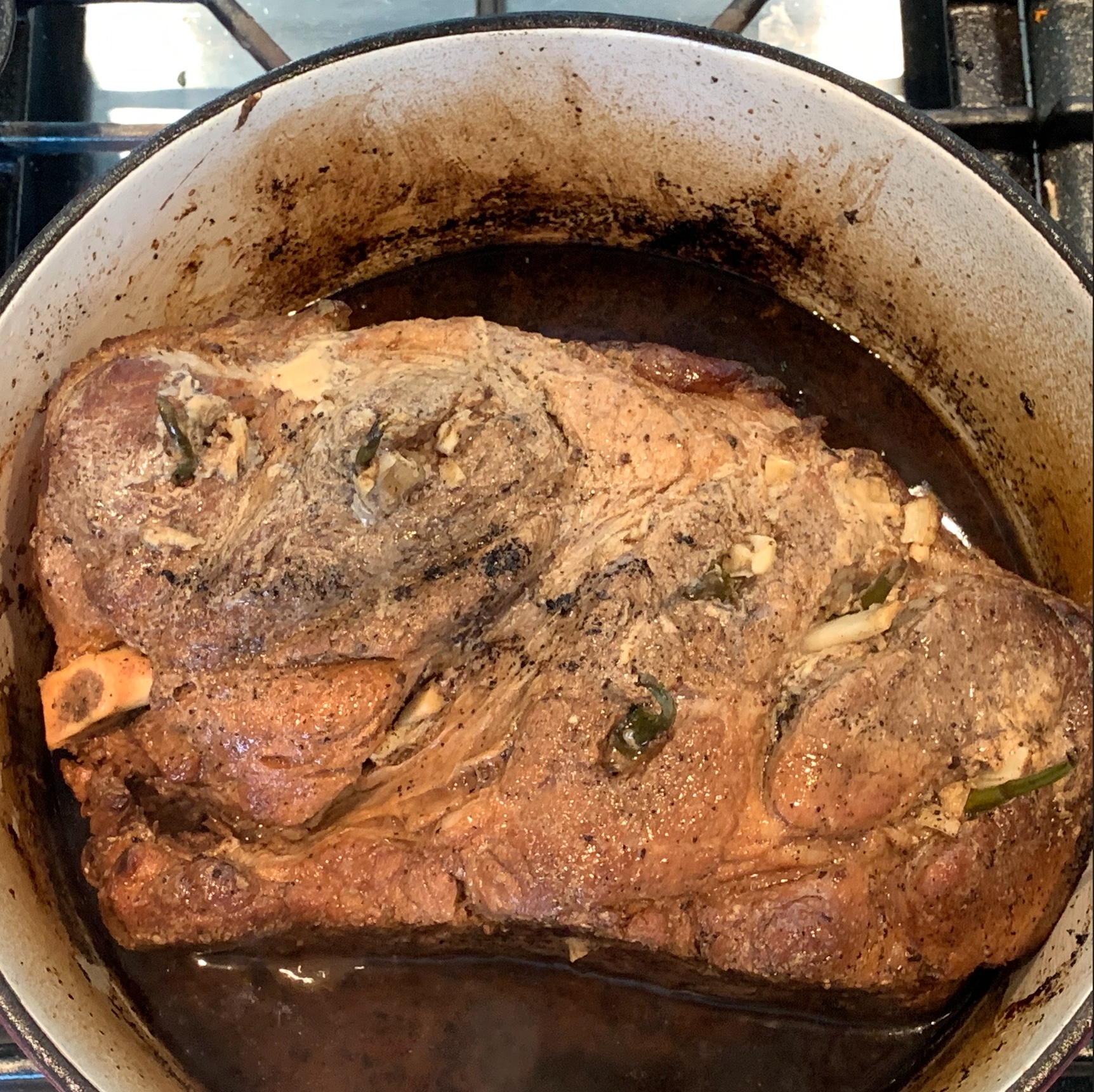 The pork shoulder set on its side in the dutch oven to help keep the lid closed