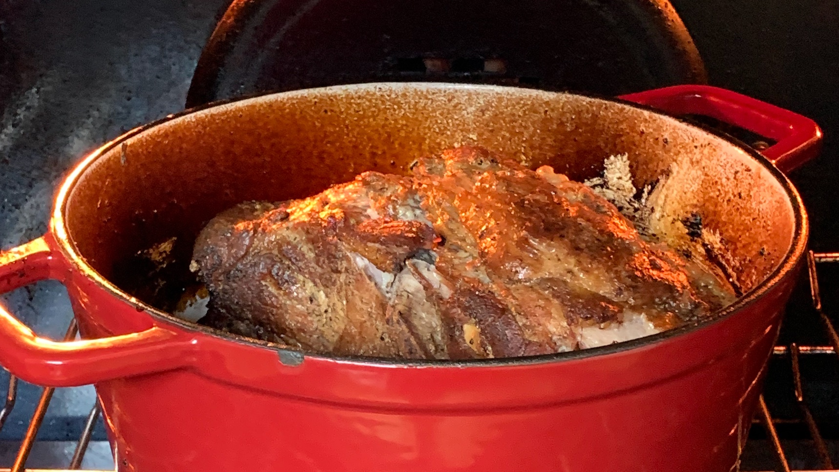 Open dutch oven with almost finished pork shoulder